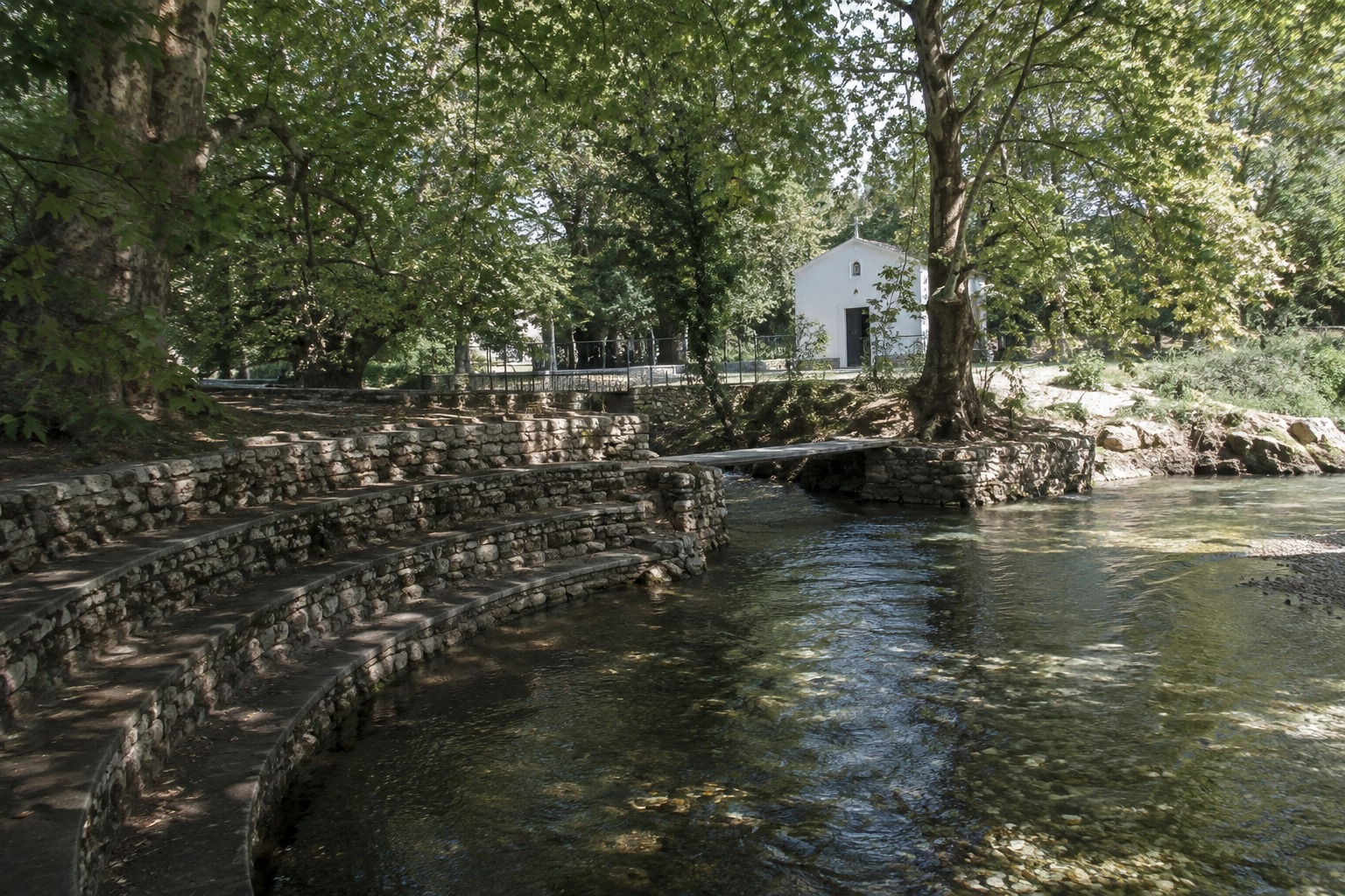 Flusslandschaft bei Philippi mit Bäumen und einer kleinen Kapelle